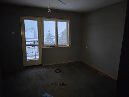 Turn this room into a kitchen in a minimalist style. The color scheme should be warm and cozy. The kitchen should be functional and include cabinets and drawers. There should be a long kitchen countertop along the wall, with cabinets above it, and maybe a kitchen island. Kitchen must be light and cosy